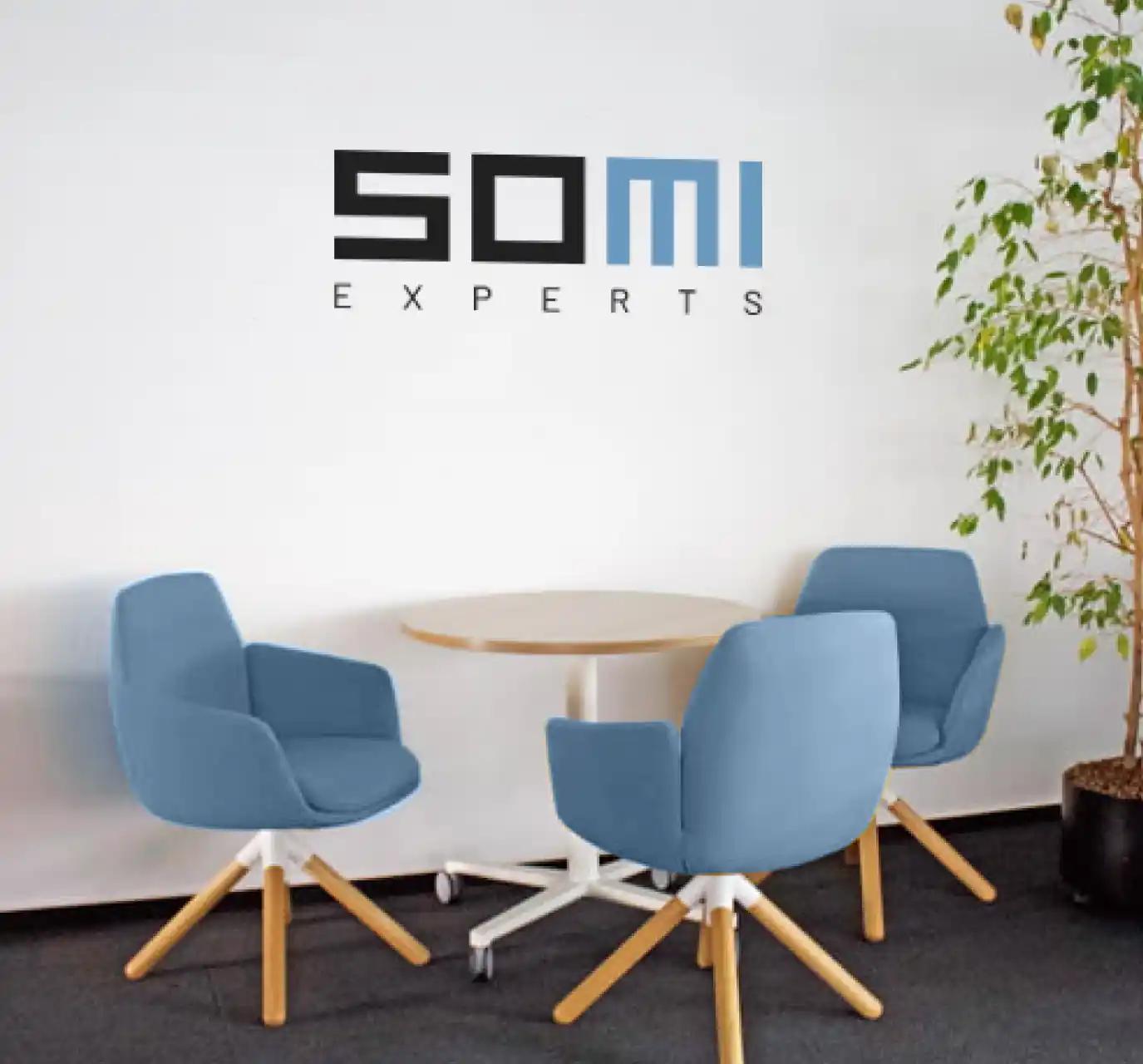 Moderne Büroräume mit einem Besprechungsbereich mit SOMI-Logo an der Wand